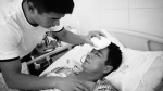 丁麦伦在医院照顾受伤的父亲（图片由消防部门提供） - 新浪河南