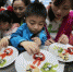 资料图。志愿者与南京留守儿童共同制作富有创意的水果拼盘。泱波 摄 - News.Zynews.Com