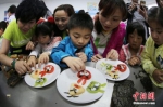 资料图。志愿者与南京留守儿童共同制作富有创意的水果拼盘。泱波 摄 - News.Zynews.Com