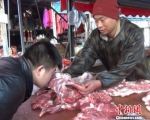 资料图：一位卖羊肉的摊贩正在教顾客从肉质、色泽、气味等方面识别瘦肉精羊肉 阚力 摄 - News.Zynews.Com