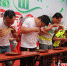 男子组参赛游客正在狼吞虎咽地吃着或甜或酸或辣的调味粽子。马显飞 摄 - 中国新闻社河南分社