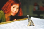 7月10日，在河南新密，中国社会科学院考古研究所河南新砦队的工作人员在查看出土的彩绘陶鸟。 - 新浪河南