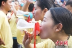 图为两名女游客手持奶瓶争分夺秒比赛喝啤酒。　贾亲亲　摄 - 河南一百度