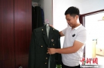 虽然已经退伍，但洪斌还是会经常整理他的常服。　尚明侠 摄 - 中国新闻社河南分社
