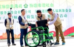 图为志愿者演示使用轮椅 - 残疾人联合会