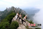 美女组团2000米绝壁“玩命”挑战悬崖瑜伽迎接国际瑜伽日 - 中国新闻社河南分社