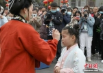 4月3日，清明假期首日，河南省开封市举行敬圣人、点朱砂等传统礼仪的“成童礼”。“成童礼”是古代中国教育子女的一种礼仪。图为老师为儿童点朱砂。 中新社记者 阚力 摄 - 中国新闻社河南分社