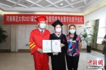 　图为在妈妈的陪伴下，孙莹获得学士学位证书。李昂 摄 - 中国新闻社河南分社