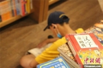 图为书店内，席地而坐认真阅读的小学生。　李明明 摄 - 中国新闻社河南分社