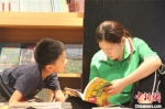 图为书店内享受亲子阅读时光的母子二人。　李明明 摄 - 中国新闻社河南分社