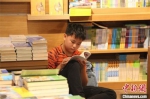 　被书籍围绕，小学生仿佛置身于书籍的海洋。　李明明 摄 - 中国新闻社河南分社