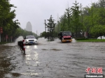 　图为车辆经过郑州市区文化路的一处积水点。　李贵刚 摄 - 中国新闻社河南分社