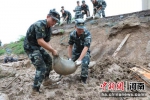 图为武警官兵在受灾现场清淤。 阚力 摄 - 中国新闻社河南分社