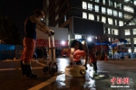 图为医院亮灯后连夜工作的消防在收水带。 李超庆 摄 - 中国新闻社河南分社