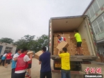 郑州市高新区管委会双桥办事处工作人员与志愿者搬运捐赠物资。　姜涛 摄 - 中国新闻社河南分社
