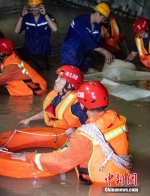 图为武汉消防员在及腰积水中开展抢排工作。艾诗洋 摄 - 中国新闻社河南分社