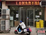 　图为8月10日，一名外卖小哥在郑州市一家饭店门口等待取餐。 中新社记者 韩章云 摄 - 中国新闻社河南分社