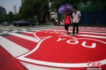 资料图：一对恋人走过成都街头的“爱情斑马线”。张浪 摄 - 中国新闻社河南分社