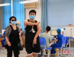 图为一名学生在家长陪同下接种疫苗。 中新社记者 阚力 摄 - 中国新闻社河南分社