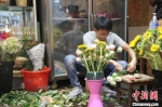 　图为一名男子正在插花做花束。　李明明 摄 - 中国新闻社河南分社
