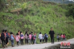 资料图：一名“90后”乡村教师组织学生排队上下学。 中新社记者 瞿宏伦 摄 - 中国新闻社河南分社