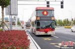 　　图为载着新人们的双层公交婚车在市区行驶。　王威 摄 - 中国新闻社河南分社