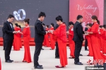 　　图为新人们在集体婚礼现场交换婚戒。　王威 摄 - 中国新闻社河南分社