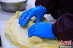图为1月21日，在一家制作“卷尖”的作坊，工人在制作鸡蛋皮。　邓小强 摄 - 中国新闻社河南分社