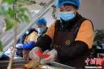 　图为1月21日，在一家制作“卷尖”的作坊，工人在对制作好的“卷尖”进进行包装。　邓小强 摄 - 中国新闻社河南分社