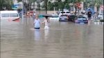 暖！暴雨突至积水过膝，有个身影在接送市民安全过马路 - 河南一百度