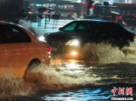 图为汽车经过积水路段。杨大勇 摄 - 中国新闻社河南分社