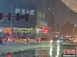 图为汽车在积水道路上行驶。杨大勇 摄 - 中国新闻社河南分社