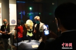 图为观众拍摄戴金面罩青铜人头像。 中新社发 程航 摄 - 中国新闻社河南分社