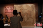 图为观众拍摄胡人牵驼壁画。 中新社发 程航 摄 - 中国新闻社河南分社
