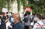 图为学生志愿者举起“迎新”标志。程航 摄 - 中国新闻社河南分社