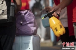 图为志愿者对行李进行消毒。程航 摄 - 中国新闻社河南分社