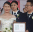 参加集体婚礼的新人收到婚礼纪念照片。韩章云 摄 - 中国新闻社河南分社
