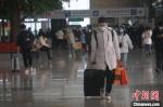 　一位旅客拖着行李在郑州东站候车大厅行走。　韩章云 摄 - 中国新闻社河南分社