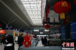 　郑州东站服务台挂上喜庆的灯笼，年味十足。　韩章云 摄 - 中国新闻社河南分社