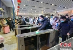 1月27日，旅客在新乡东站过检票闸机。　常昊 摄 - 中国新闻社河南分社