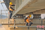 　图为铁路职工在铁路桥梁上进行检测维护作业。　张中海 摄 - 中国新闻社河南分社