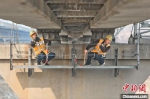　图为铁路职工在铁路桥梁上进行检测维护作业。　张中海 摄 - 中国新闻社河南分社