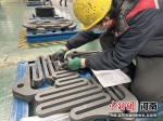 图为工人在对特种石墨产品进行测量。 王宇 摄 - 中国新闻社河南分社
