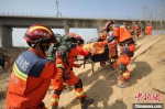 图为模拟道路受损，救援人员徒步前往震中。　李宏鹏 摄 - 中国新闻社河南分社