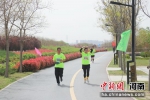 选手奔跑比心，享受运动带来的快乐。赵齐睿 摄 - 中国新闻社河南分社