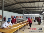 图为麻花手工艺人们正在制作“麻花王”。 王衡 摄 - 中国新闻社河南分社