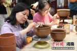 大学生们正在学习制作花瓣纹仰韶彩陶。 王宇 摄 - 中国新闻社河南分社