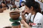 大学生们正在学习制作花瓣纹仰韶彩陶。 王宇 摄 - 中国新闻社河南分社
