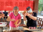 小区业主展示自己包的粽子。 翟娟娟 摄 - 中国新闻社河南分社