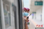 　图为重庆客运段列车长李海英用对讲机与高铁司机进行联控。　苏志刚 摄 - 中国新闻社河南分社